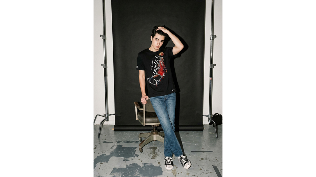 Person posing in front of a black backdrop in a studio setting