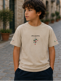 Beige t-shirt with brand logo and graphics, shown from front, back, and side views, worn by a child.