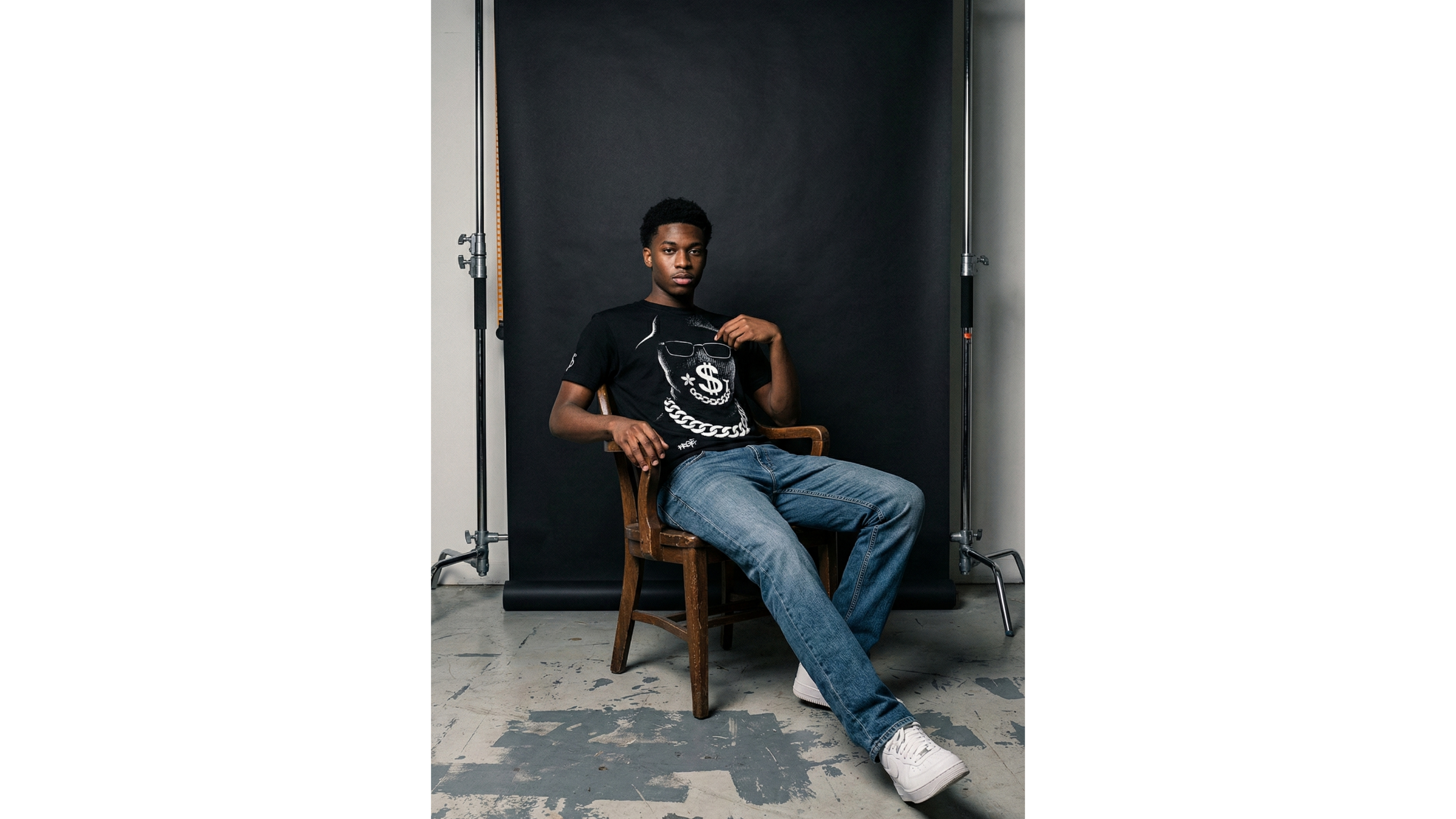 Person sitting on a chair in a room with a black backdrop