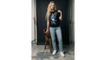 Person wearing a graphic t-shirt and jeans standing in a studio setting.