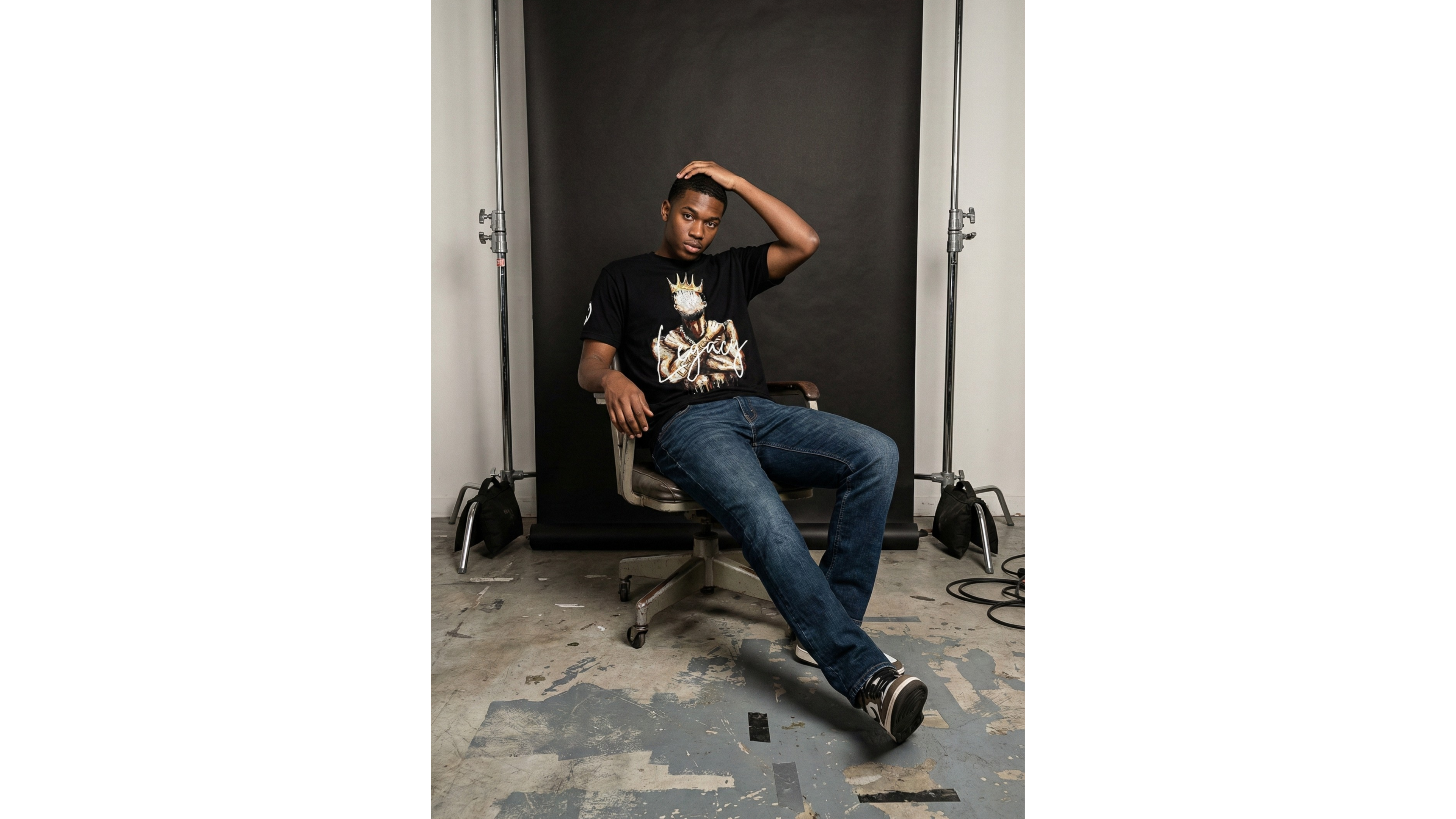 Person sitting on a chair in a room with a black backdrop