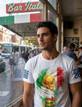 Man wearing a white t-shirt with a colorful design, standing in front of a window with 'Bar Italia' sign.